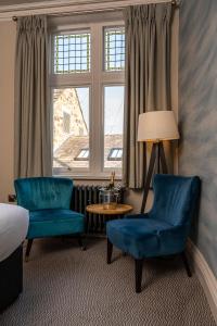 a room with two blue chairs and a window at The Fleece Hotel Richmond in Richmond