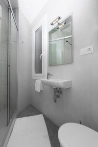 a bathroom with a sink and a toilet and a mirror at Centric Sagrada Familia Apartments in Barcelona