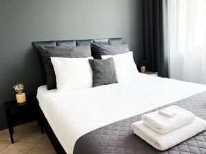 a bedroom with a large white bed with two towels on it at Pokoje Gościnne Przy Molo in Gdynia