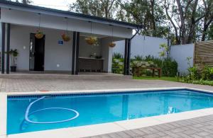 a swimming pool in front of a house at “Pop Inn” modern apartment in heart of Bryanston in Johannesburg