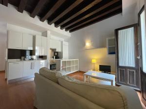a living room with a couch and a kitchen at Palacio Santa Ursula in Toledo