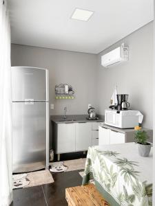 uma cozinha com um frigorífico de aço inoxidável e um lavatório em Container na montanha em Siderópolis