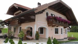 una casa con un balcón con flores. en Landhaus Widlroither en Mondsee