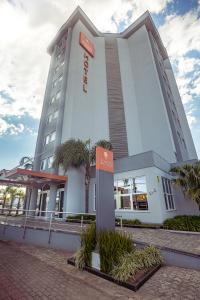 a hotel building with a sign in front of it at Zago Hotel in Lages