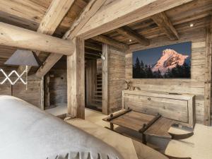 ein Schlafzimmer in einem Blockhaus mit einem TV an der Wand in der Unterkunft Chalet La Clusaz, 5 pièces, 11 personnes - FR-1-304-229 in La Clusaz