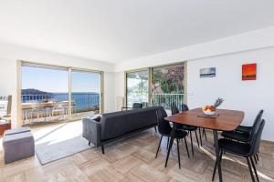 een woonkamer met een tafel en een bank bij Villefranche Sur Mer:Appartement-villa, Vue mer, jardin, parking. in Villefranche-sur-Mer