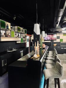 a kitchen with a long bar with a row of stools at DORMERO Hotel Aschaffenburg in Aschaffenburg