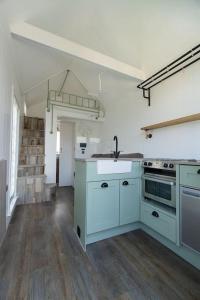 an empty kitchen with a sink and a stove at The Shepherd's Hut, Quex Park Estate in Birchington