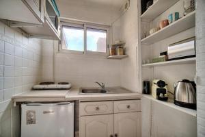 a small white kitchen with a sink and a window at IMMOGROOM - Near the city centre and the beach - Air conditioning - Terrace in Cannes