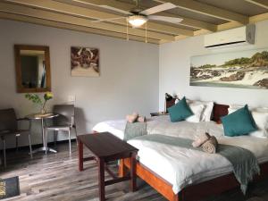 pokój z dwoma łóżkami i stołem w obiekcie White Sands Lodge w mieście Divundu