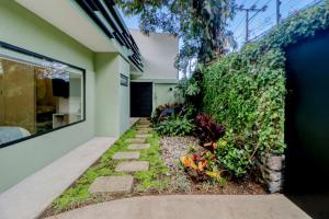 a garden in the side of a house at Colina Inn in Escazu