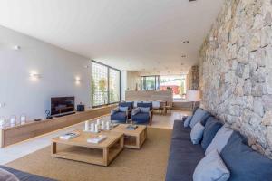 a living room with a blue couch and a stone wall at Moderna Villa con vistas al mar en Alcudia in Alcudia