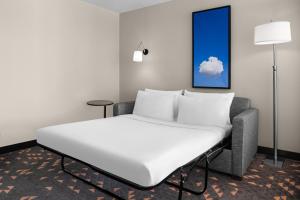 a bed in a room with a cloud painting on the wall at Holiday Inn Hasbrouck Heights-Meadowlands by IHG in Hasbrouck Heights