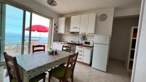 a kitchen with a table and a view of the ocean at La Terrazza in Gioiosa Marea