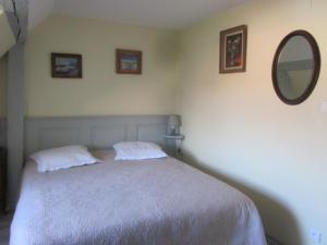 Schlafzimmer mit einem Bett und einem Spiegel an der Wand in der Unterkunft Gîte chez Jeanne in Ebersheim