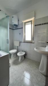 a bathroom with two toilets and a sink and a window at La Terrazza in Gioiosa Marea