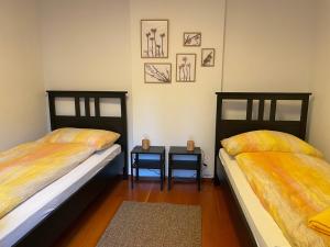two beds in a room with two side tables at Ascona: CÀ DAL DOLZ in Ascona