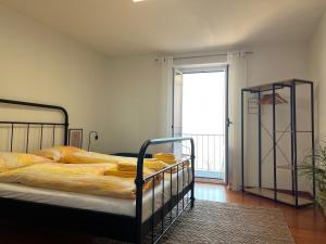 a bedroom with a bed and a large window at Ascona: CÀ DAL DOLZ in Ascona