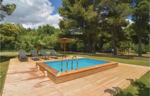una piscina su una terrazza in legno con sedie e ombrellone di Lovely Home In Villen-Lès-Maguelone a Villeneuve-lès-Maguelonne