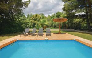 una piscina blu con sedie e ombrellone di Lovely Home In Villen-Lès-Maguelone a Villeneuve-lès-Maguelonne Altre 24 foto