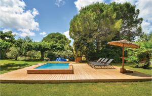 a wooden deck with a pool and an umbrella at 3 Bedroom Stunning Home In Villen,-ls-maguelone in Villeneuve-lès-Maguelonne