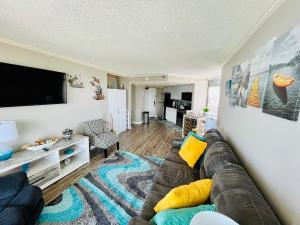 uma sala de estar com um sofá e uma televisão de ecrã plano em 1602 Coastal Soul Pet friendly em Myrtle Beach