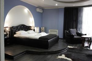 ein Schlafzimmer mit einem Bett, einem Stuhl und einem Spiegel in der Unterkunft Alians in Krasnodar