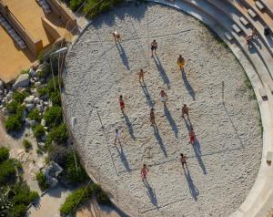 a group of people playing a game in the sand at Corinthia St George's Bay in St. Julianʼs