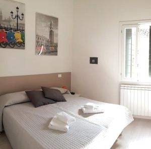1 dormitorio con 1 cama blanca y 2 toallas en Attico Biennale Venezia Nuovissimo, en Venecia