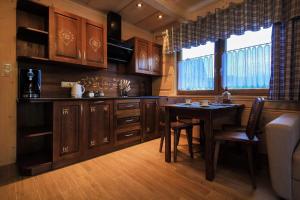 a kitchen with wooden cabinets and a table and a window at Domek Dream Holiday in Poronin