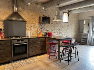 a kitchen with a stove and a counter with stools at Ferienhaus Côté Dentelles am Fuß der Dentelles de Montmirail in Vacqueyras