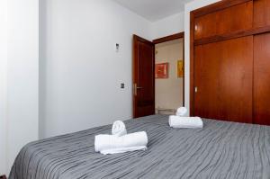 ein Schlafzimmer mit einem Bett mit zwei Handtüchern darauf in der Unterkunft YourHouse BlauBlue 2 1, sea view apartment in Can Picafort