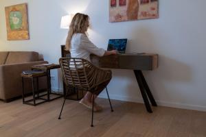 a woman standing at a desk with a laptop at Ferienwohnungen Schnabel im Herzen von Rottach-Egern - Wohnung Wallberg in Rottach-Egern