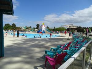 een groep stoelen in een zwembad bij een waterpark bij Escape MobilHome aux Dunes de Contis in Saint-Julien-en-Born