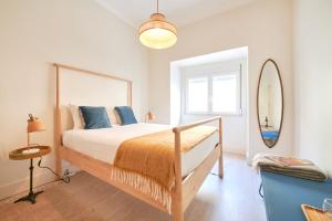 - une chambre avec un grand lit et un miroir dans l'établissement Charming 3BR APT w/ patio, by TimeCooler, à Lisbonne
