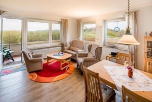 a living room with a table and chairs and windows at Möwe - a65690 in Baltrum