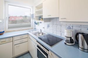 a white kitchen with a sink and a window at Möwe - a65690 in Baltrum