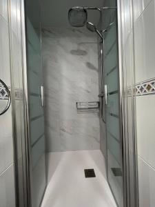 une salle de bain avec une douche avec une porte vitrée dans l'établissement Amplio y céntrico piso con patio., à La Corogne