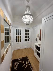 un pasillo con una lámpara de araña y una habitación con paredes blancas en Amplio y céntrico piso con patio., en A Coruña