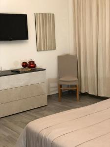 - une chambre avec une commode, une télévision et une chaise dans l'établissement B&B SKY LINE, à Crotone