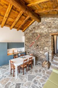 a kitchen and dining room with a table and chairs at Agriturismo Valliera in Castelmagno