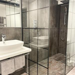 a bathroom with a glass shower and a sink at Booking Urban at Halstead in Halstead