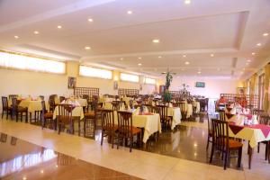 - un restaurant avec des tables et des chaises dans une salle dans l'établissement Yaya Africa Athletics Village, à Sululta