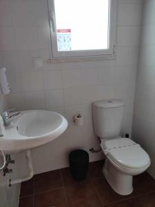 a bathroom with a toilet and a sink and a window at Di&Ana II - Alojamento Redondo in Redondo