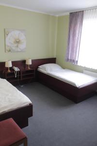 um quarto de hotel com duas camas e uma janela em Landhaus Zum alten Fritz em Seesen
