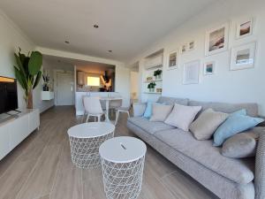 a living room with a couch and two tables at S'Agaró Apartment with sea views and pool in Sant Feliu de Guixols