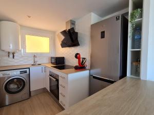 a kitchen with a sink and a washing machine at S'Agaró Apartment with sea views and pool in Sant Feliu de Guixols +15 photos