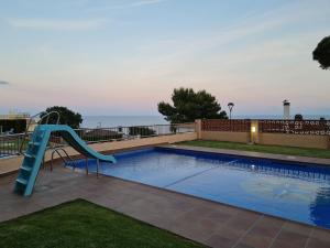 a swimming pool with a slide and a slide slide at S'Agaró Apartment with sea views and pool in Sant Feliu de Guixols