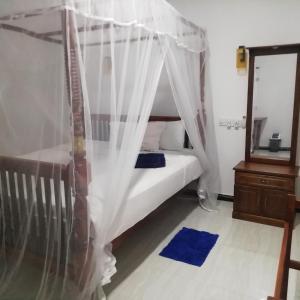 Rúm í herbergi á Sunnyplace Guest Mirissa
