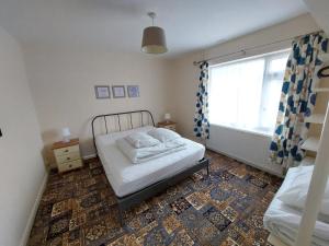 a small bedroom with a bed and a window at Dainville Lodge in Skegness